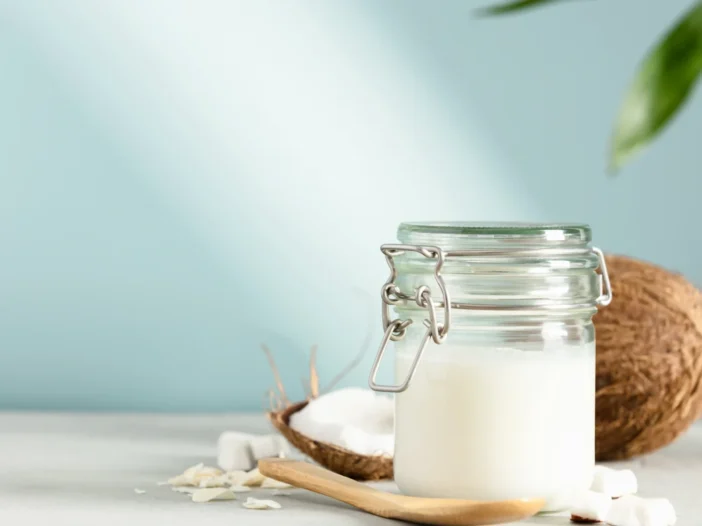 Coconut oil in a glass jar with coconut pieces, ideal for making coconut oil tinctures.